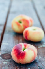 Fresh Saturn peaches on old board