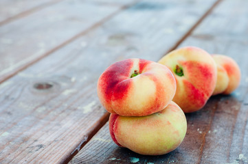 Fresh Saturn peaches on old board