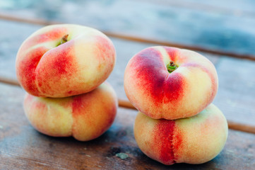Fresh Saturn peaches on old board