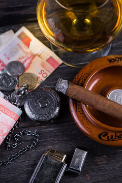 Cuban domino game on table with cigar,rum, pessos notes and pock