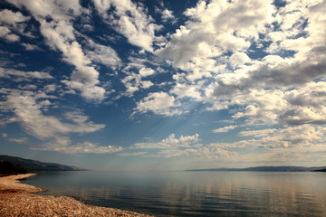 Fototapeta premium Sunshine make the way through clouds on water, Baikal lake