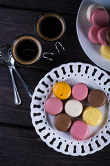 Fresh vibrant macaroons on plate with coffee
