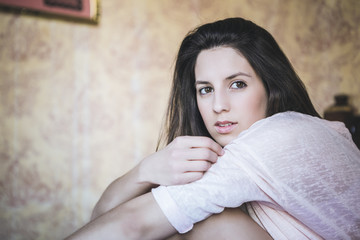 happy woman sitting on bed at home