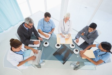 Male and female doctors using laptop