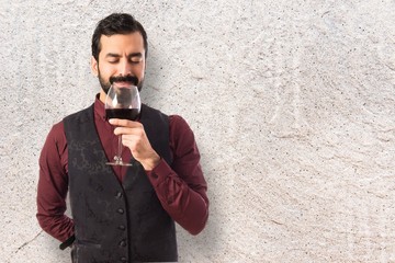 Man wearing waistcoat holding a wine glass