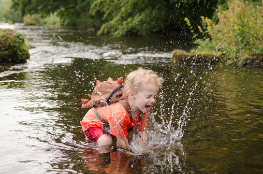 Happy boy splashing in river, Clitheroe, UK