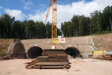 Tunnelbaustelle mit Bewehrungsgittern und Baukran