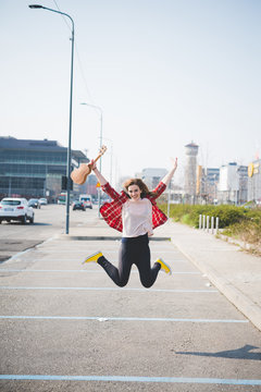 Young Woman Jumping Mid Air On Street