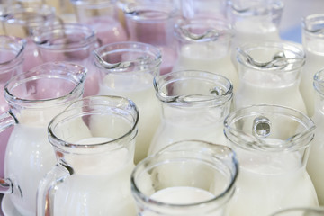many glass jugs with milk and yogurt