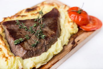 meat steak with potato puree backed on wood board