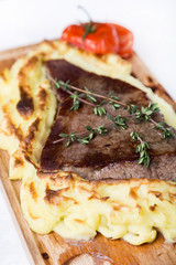 meat steak with potato puree backed on wood board