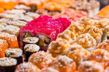 assorted sushi and rolls on wood board in dark light