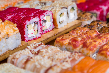 Fototapeta na wymiar assorted sushi and rolls on wood board in dark light