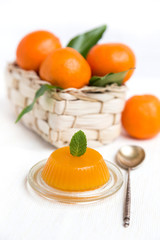 jelly and fresh orange mandarins with leafs in basket