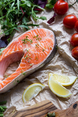steak of fresh salmon on crushed brown paper with garnish