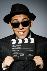 Young man in classic striped costume and hat isolated on gray