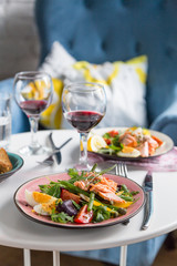 salad with salmon and verdure in plate on table with blue chair