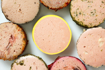 A variety of round pates on plate. From above.