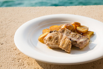 Lunch in restaurant on seaside/Grilled fillet of tuna and tasty potato in seaside restaurant