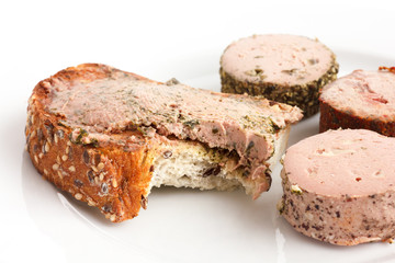 Whole grain toast spread with pate, bite missing.