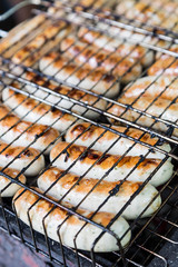 many sausage cooking in grilled barbecue