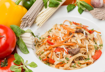 noodles with vegetables and garnish on white plate