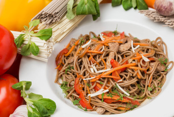 noodles with vegetables and garnish on white plate
