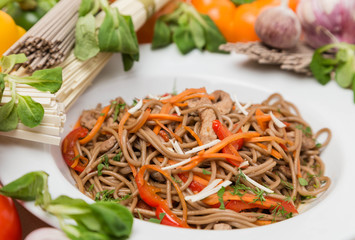 noodles with vegetables and garnish on white plate