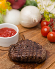 hot grilled beef with garnish on wooden board