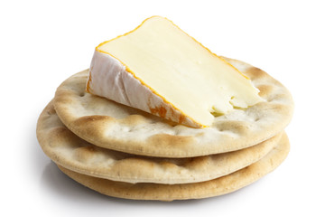 Stack of water biscuits with cheese, isolated on white.