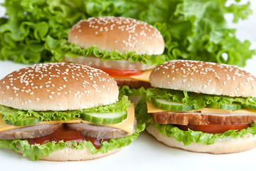 three burger with meat and vegetables