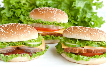 three burger with meat and vegetables