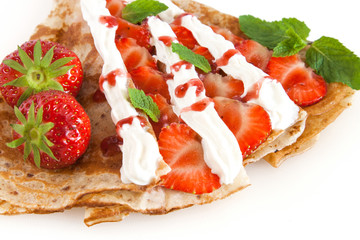 Rolled pancakes with strawberry, sweet cream and mint