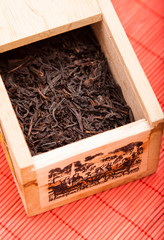 box with black tea on red mat