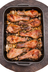 baked chicken legs in tray on black wooden