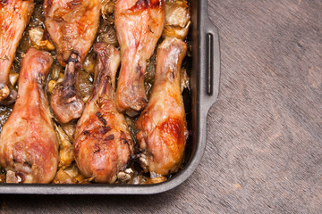 baked chicken legs in tray on black wooden