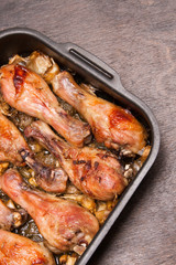 baked chicken legs in tray on black wooden