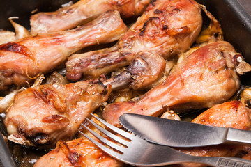 baked chicken legs in tray on black wooden