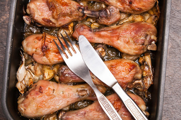 baked chicken legs in tray on black wooden