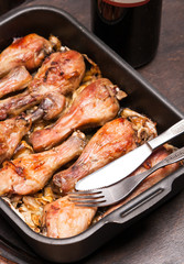 baked chicken legs in tray on black wooden