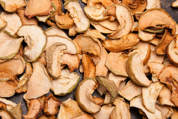 slices of dried apples as background on black