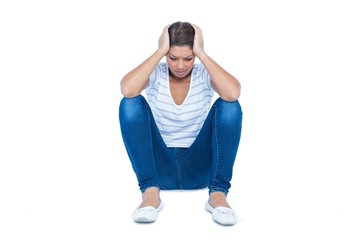 Pretty brunette sitting on floor with headache 