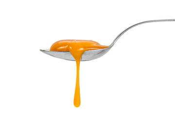 Raw egg yolk leaking from the spoon, isolated on white