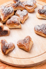 bakery hearts from split pastry with sugar powder on wooden