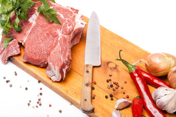 fresh meat of beef with bone on wooden spices and knife
