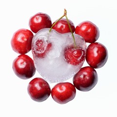 Cuore di ghiaccio con ciliegie su sfondo bianco