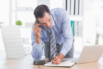 businessman phoning at his desk 