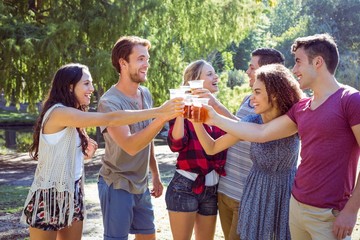 Happy friends in the park having beers