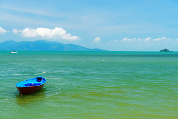 Naklejka premium A small wooden boat moored on a beach in Thailand