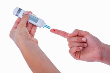 Diabetic woman using blood glucose monitor 